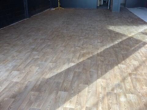 Wide commercial room completed with light timber-look flooring